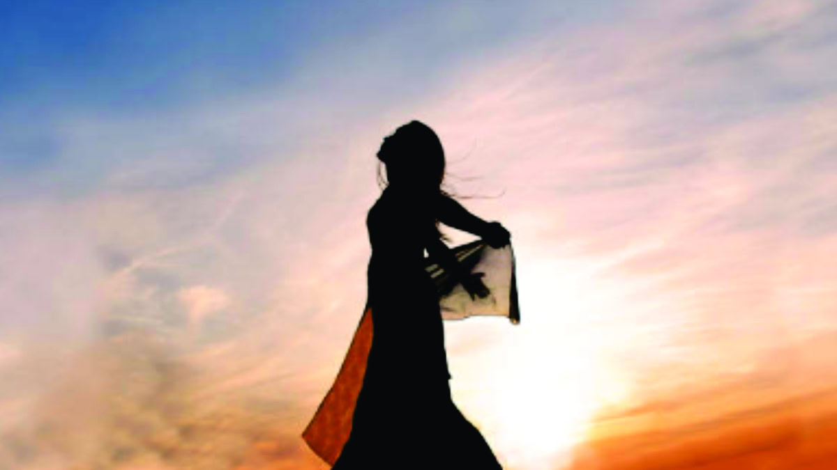 Mulher em silhueta ao pôr do sol com lenço esvoaçante, representando liberdade emocional e superação.