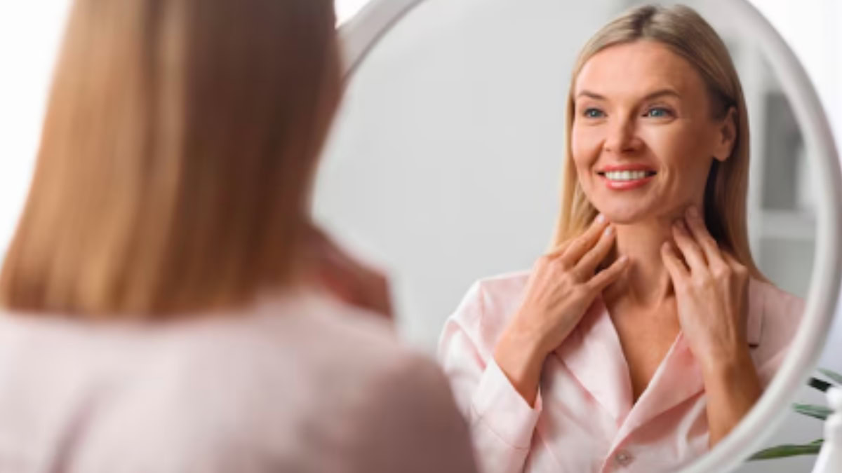Mulher sorrindo para si mesma no espelho, representando autoestima e amor-próprio.
