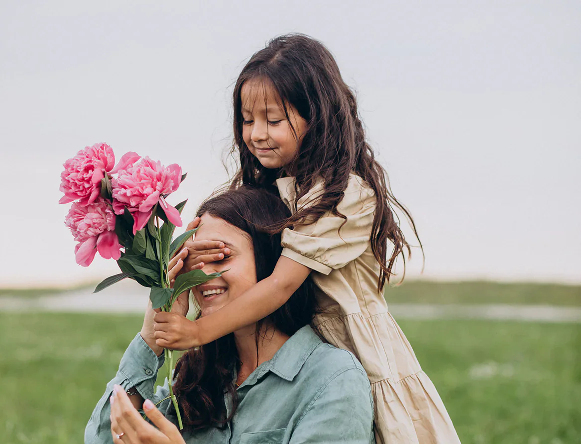 Criança entregando flores para a mãe em um momento de carinho no Dia das Mães